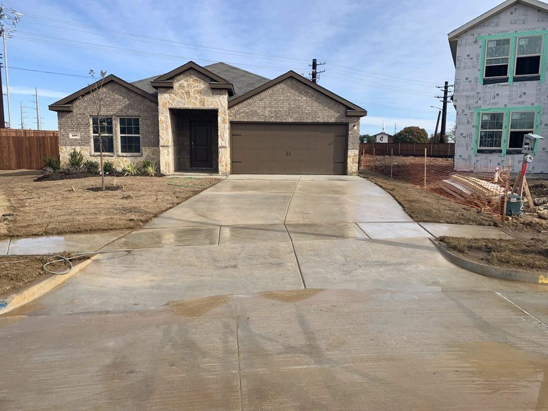 Freshly cleaned concrete driveway at a new construction home